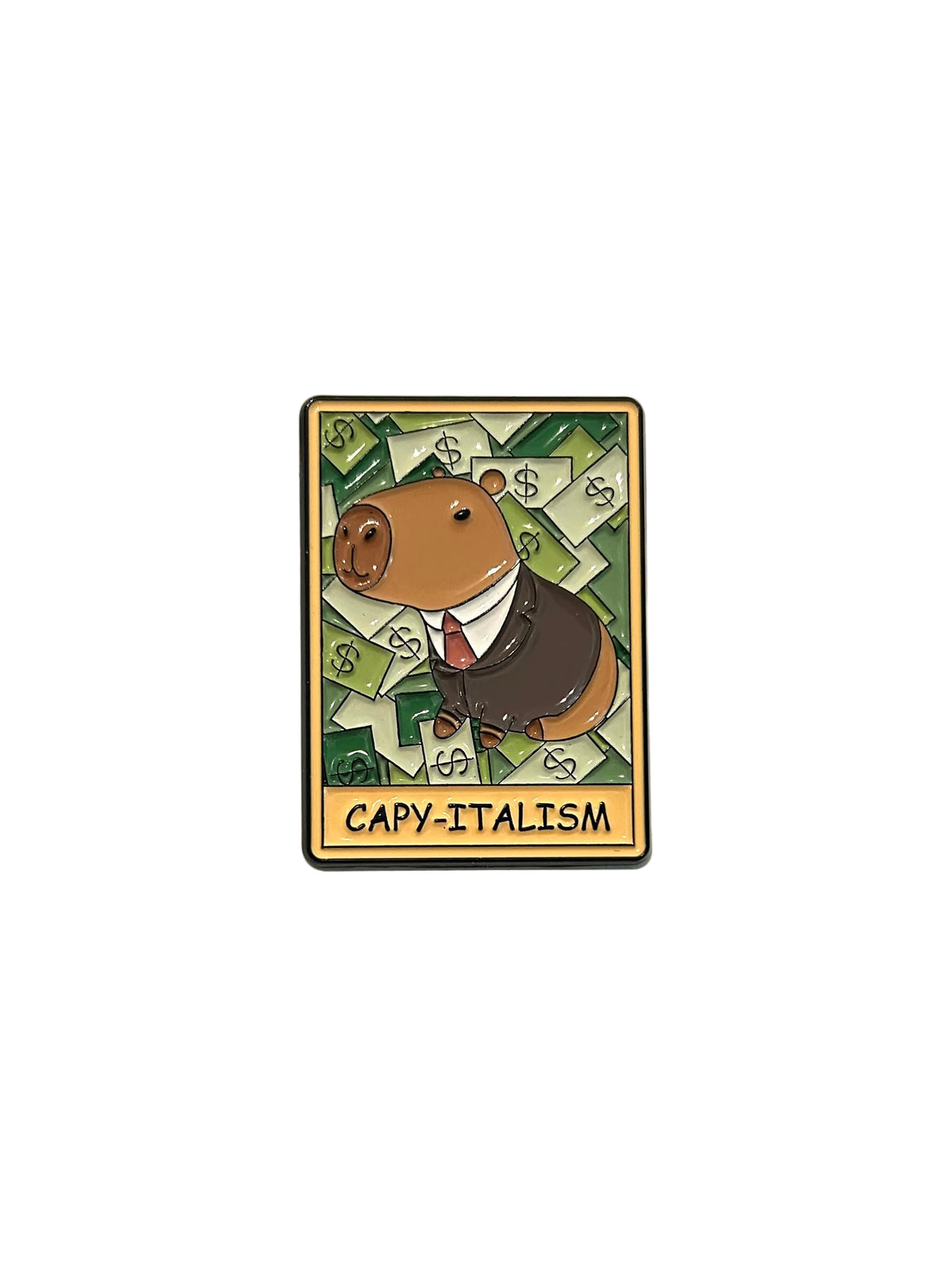 A small enamel pin shaped like a card featuring a cartoon capybara wearing a suit over green dollar bills, with the text 'CAPY-ITALISM' at the bottom. A finger is visible holding the pin against a white surface.